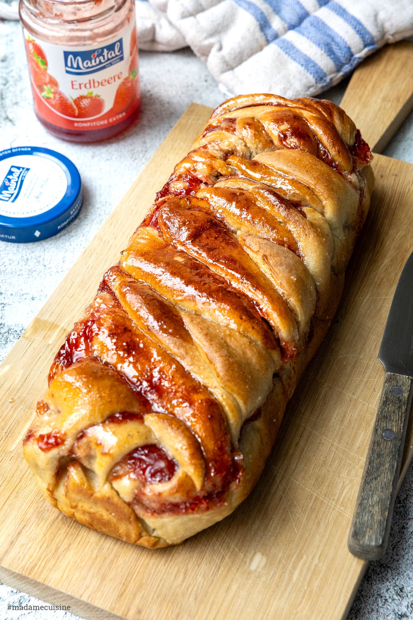fertig gebackene vegane Babka mit Zuckerglasur auf einem Holzbrett