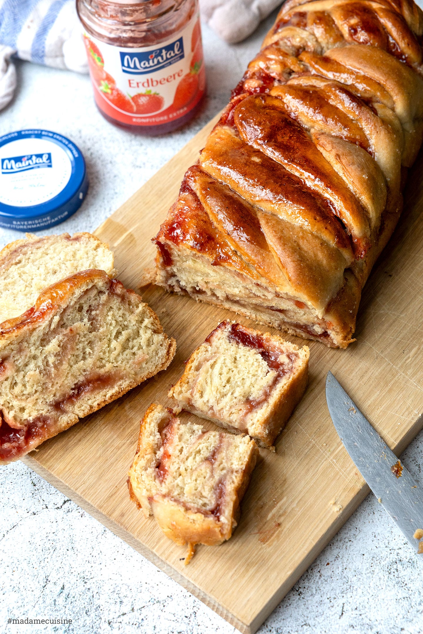 angeschnittene vegane Babka mit sichtbarer Erdbeer-Füllung, Maintal Konfitüre daneben