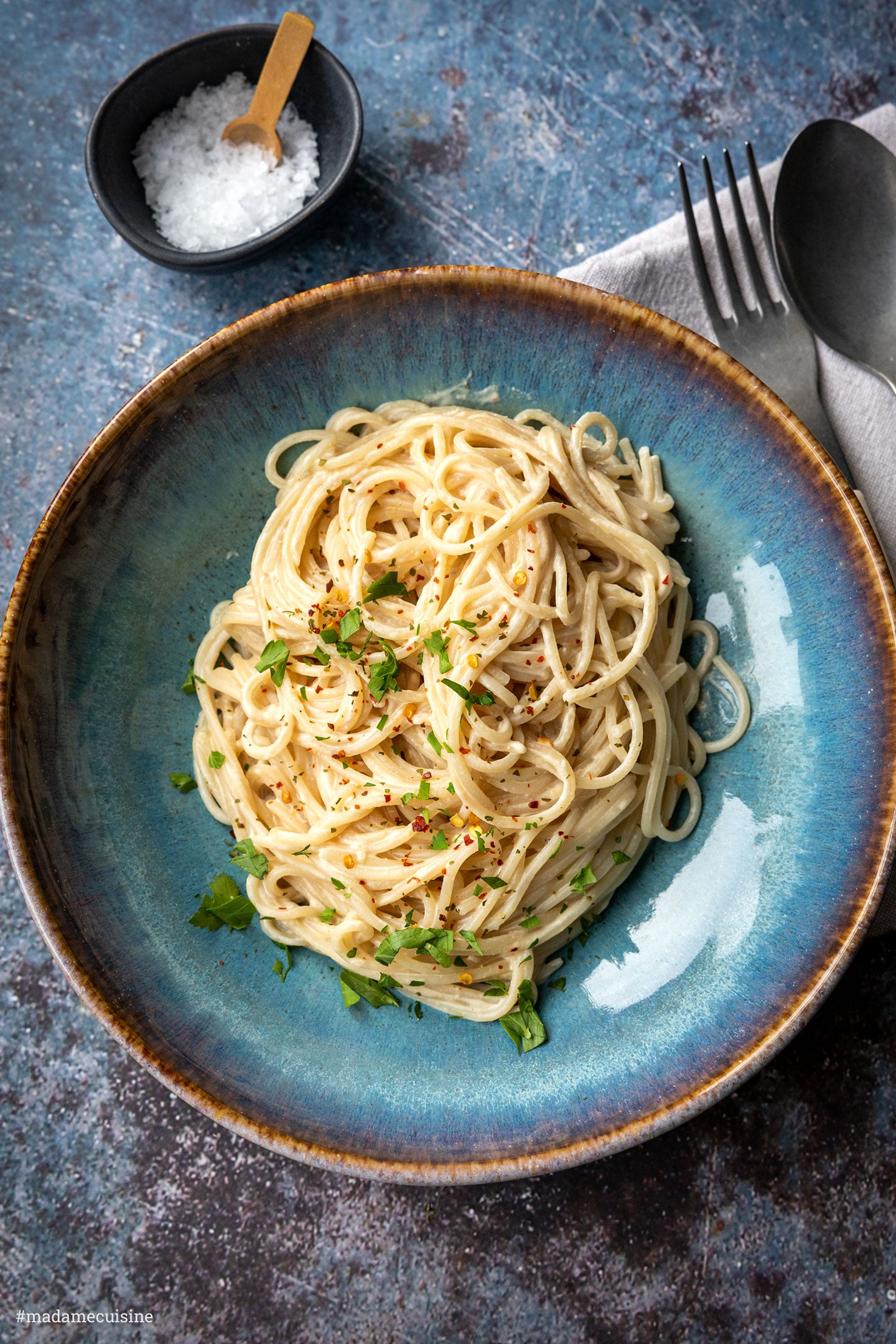 Spaghetti mit Tahini-Sauce von oben mit frischer Petersilie und Chiliflocken