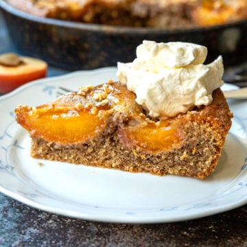 Serviervorschlag: Kuchenstück mit Sahne und Walnüssen auf Teller