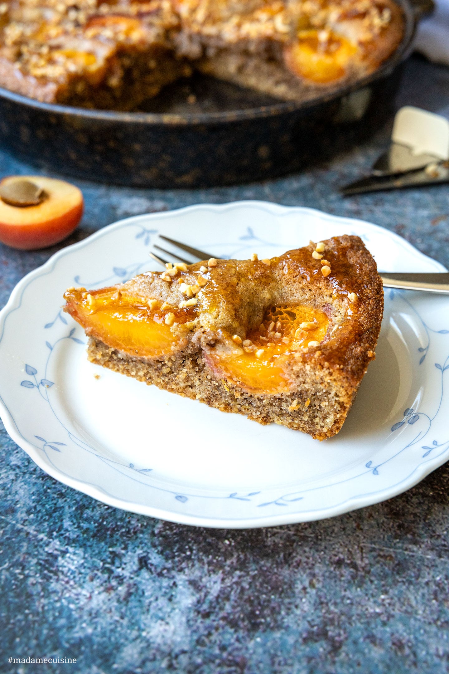 Nahaufnahme eines Kuchenstücks mit karamellisierten Aprikosen und Sahnehaube