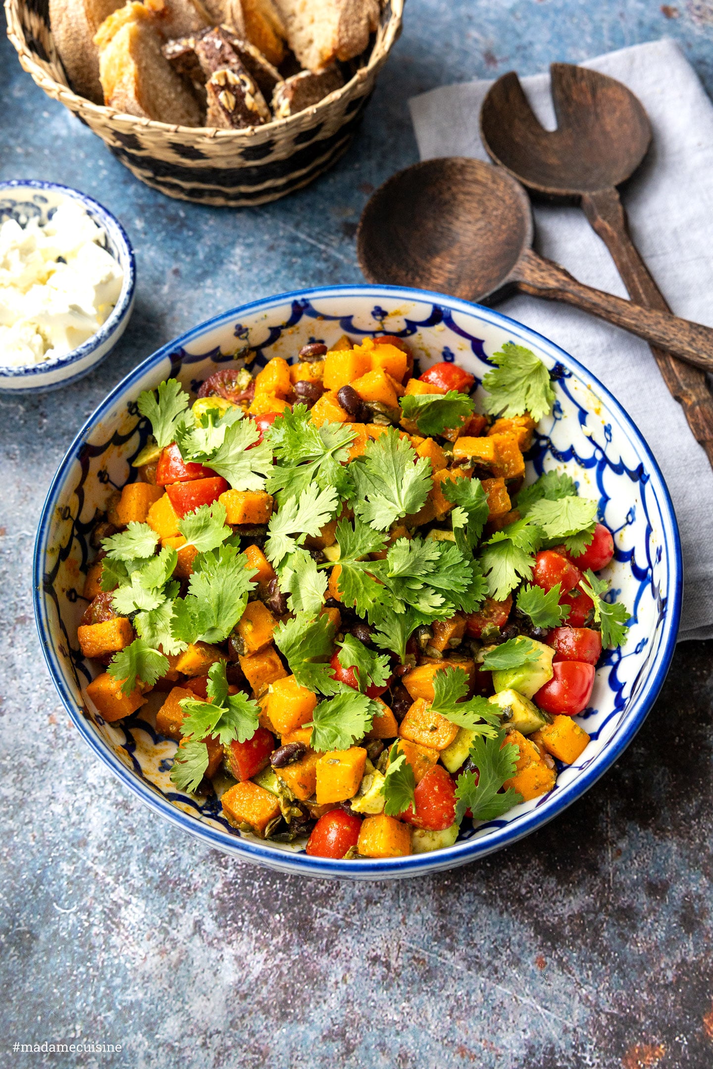Süßkartoffel-Salat mit schwarzen Bohnen und Koriander in blau-weißer Schüssel