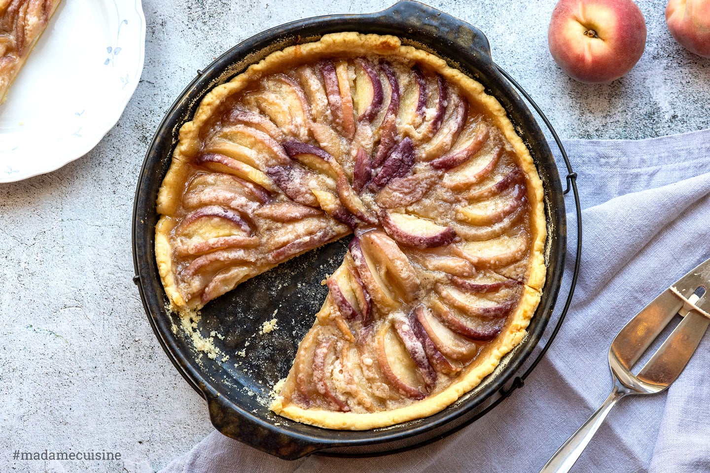 Sommerliche Pfirsich-Tarte mit Mürbeteig, frisch gebacken in der Tarteform