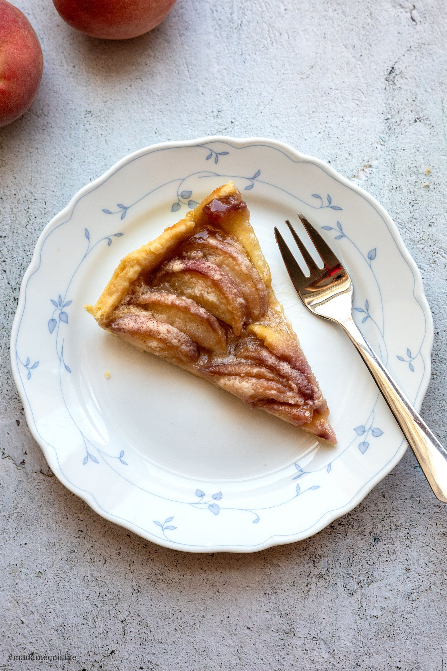 Serviertes Tarte-Stück mit saftiger Pfirsichfüllung und knusprigem Boden