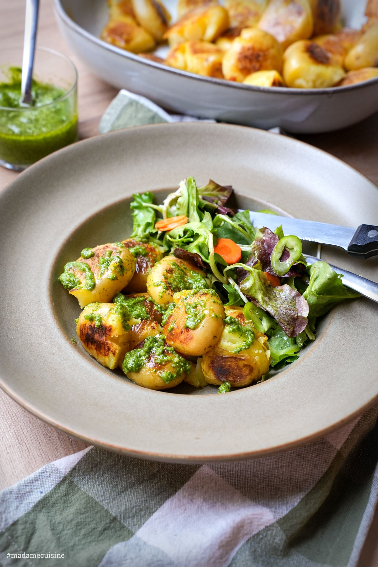 Teller mit knusprigen Kartoffeln, Pesto und buntem Blattsalat mit Karottenscheiben