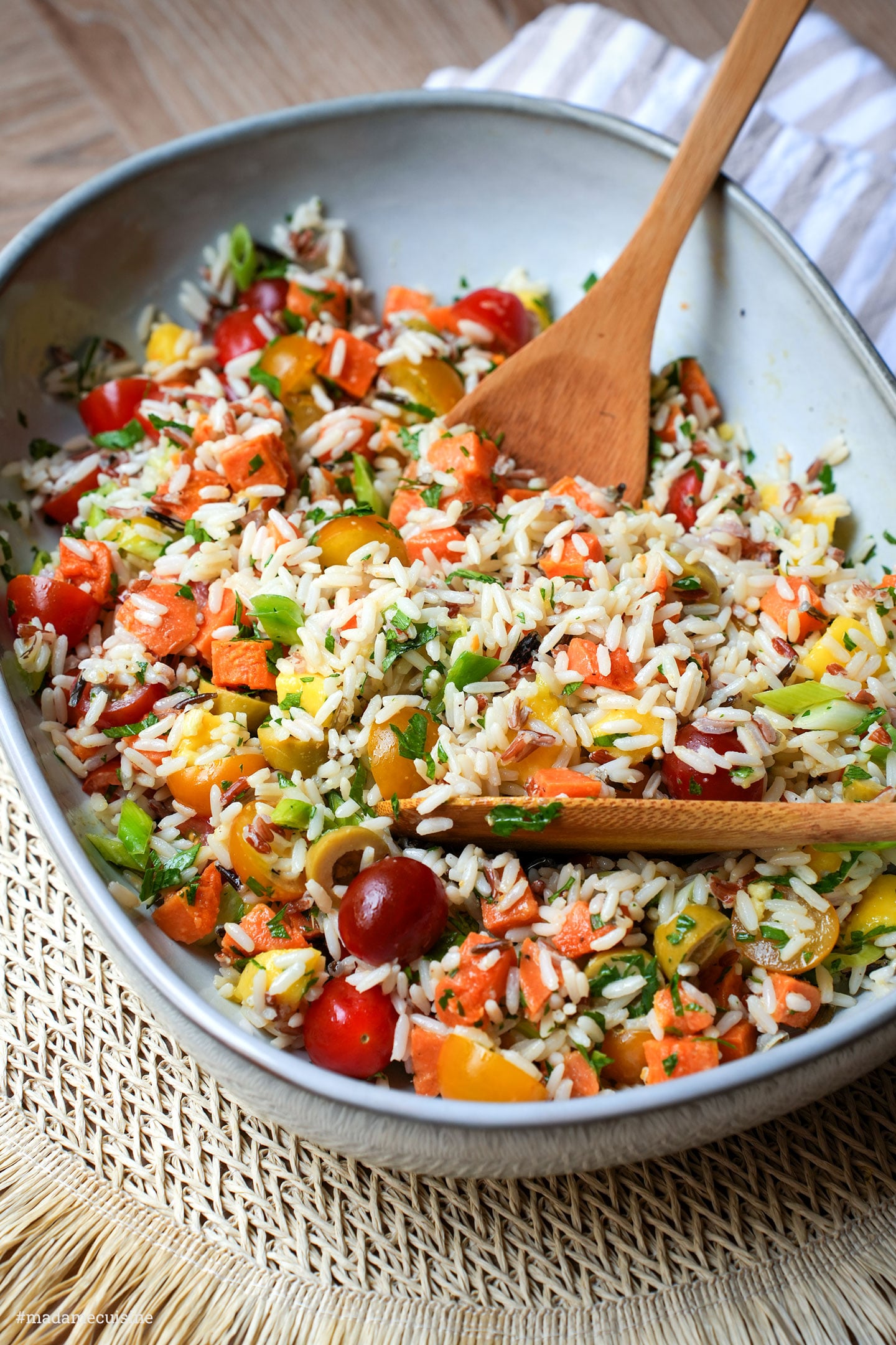 Nahaufnahme von Kirschtomaten, Süßkartoffelwürfeln und Petersilie im Reissalat