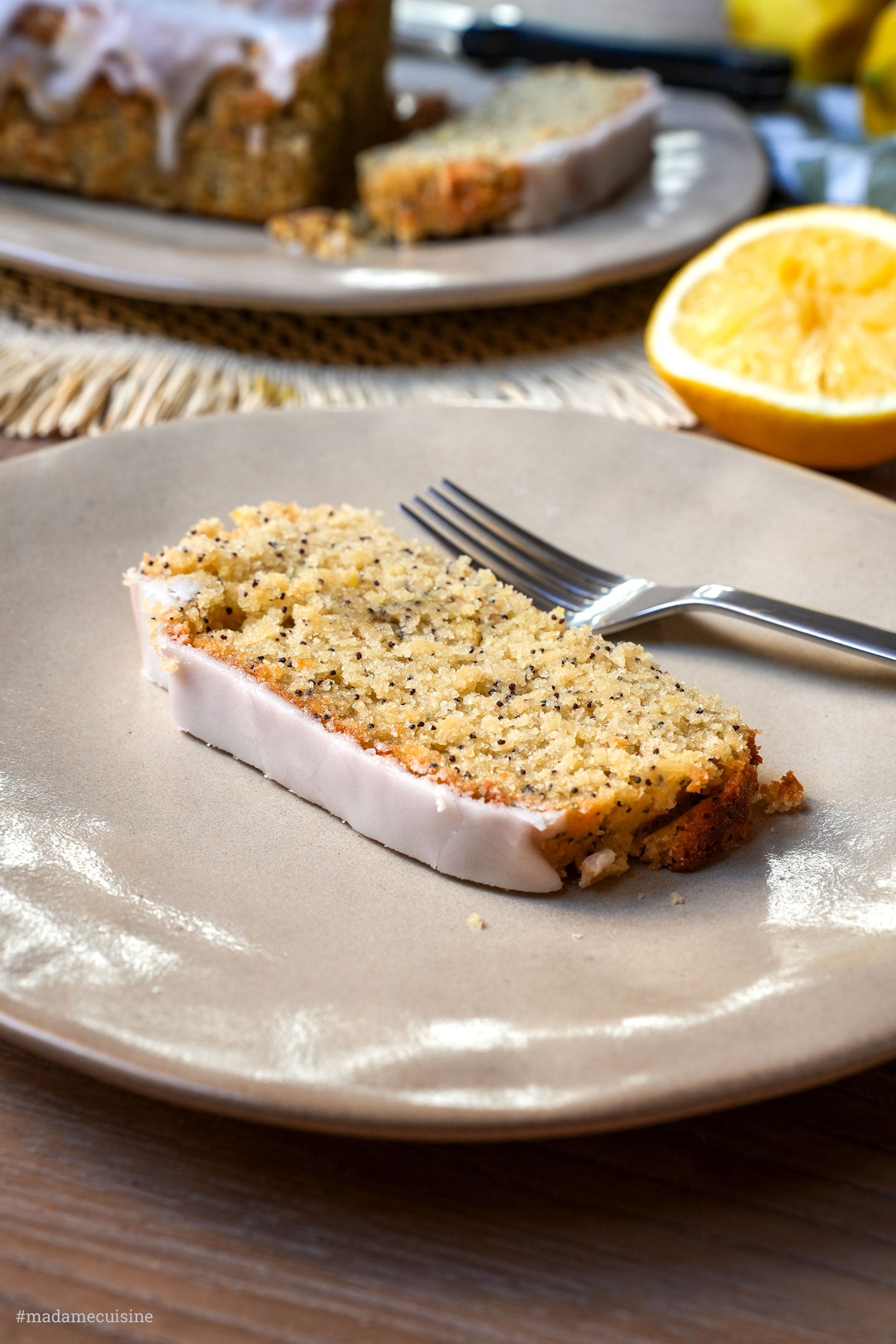 Scheibe Zitronen-Mandel-Mohn-Kuchen auf Teller mit Gabel