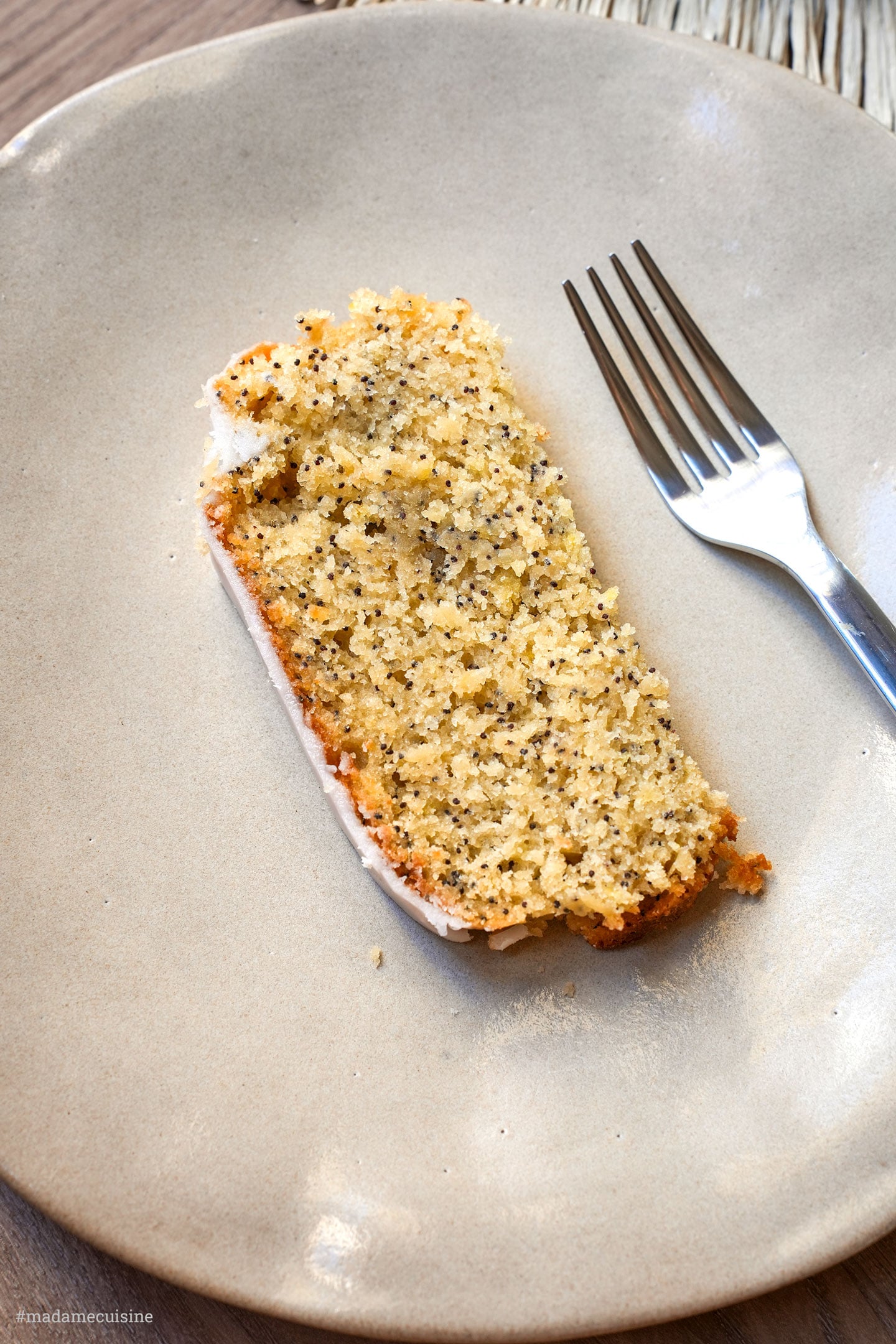 Nahaufnahme einer Scheibe veganer Zitronenkuchen mit Mohn, saftige Krume sichtbar