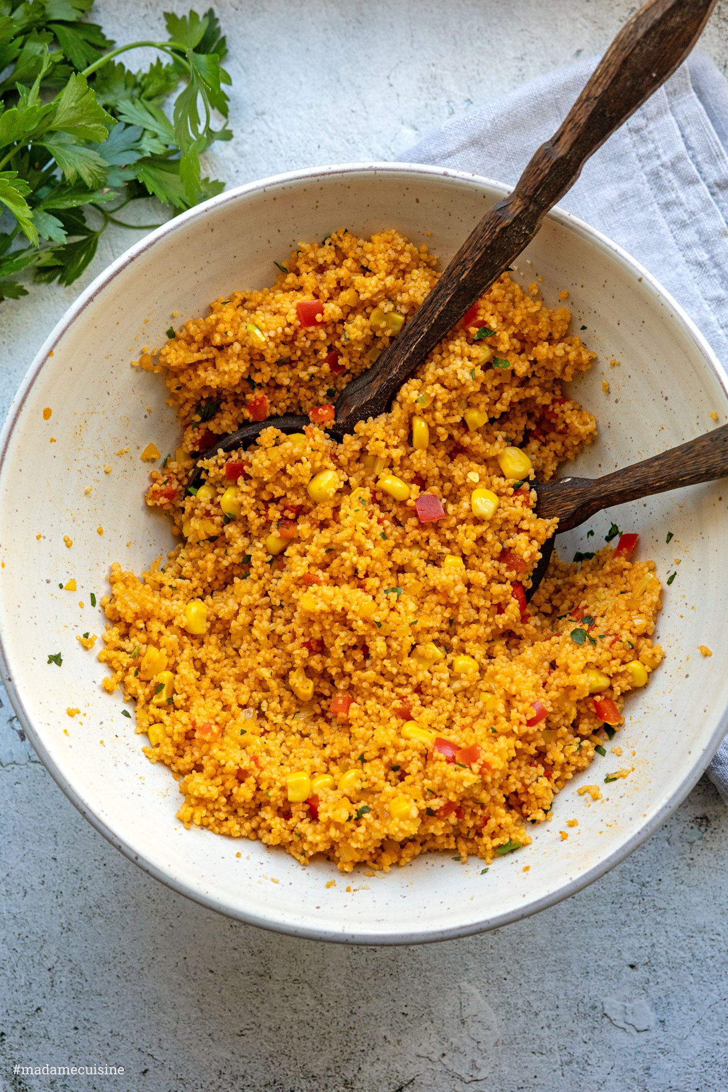 Draufsicht auf die Schüssel beim Vermischen von Couscous mit Paprika und Mais