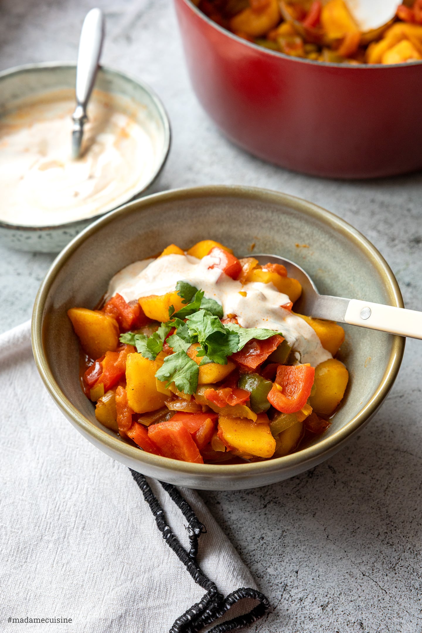 Kartoffel-Paprika-Curry mit Joghurt-Harissa-Dip, serviert mit Löffel