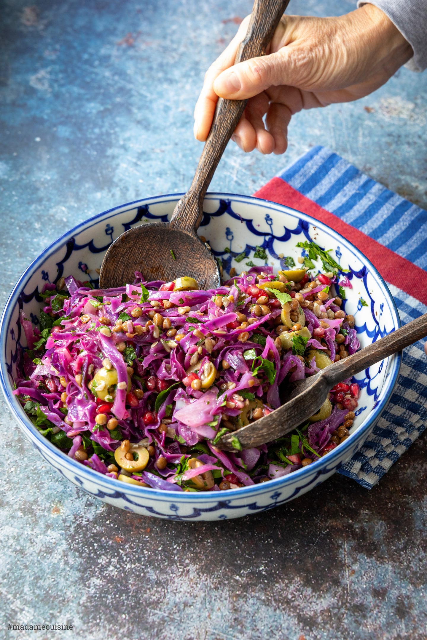 Rotkohl-Linsensalat wird in der Schüssel mit Holzbesteck vermengt